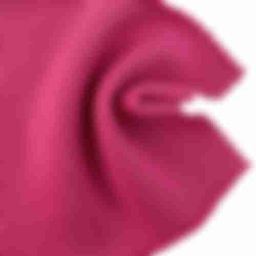 Close-up swatch of vibrant magenta 100% cotton brushed fleece fabric, showing soft drape and texture for sportswear.