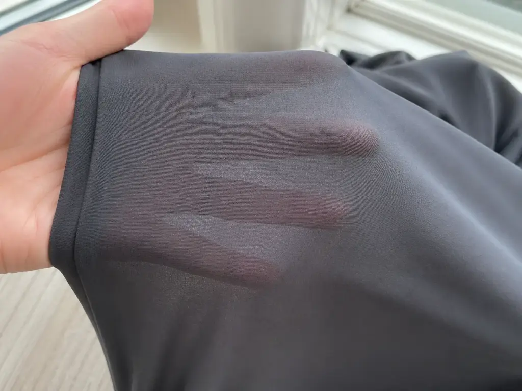 A swatch of legging fabric being stretched over a hand against a light background, showing the fabric remains opaque under stretch.